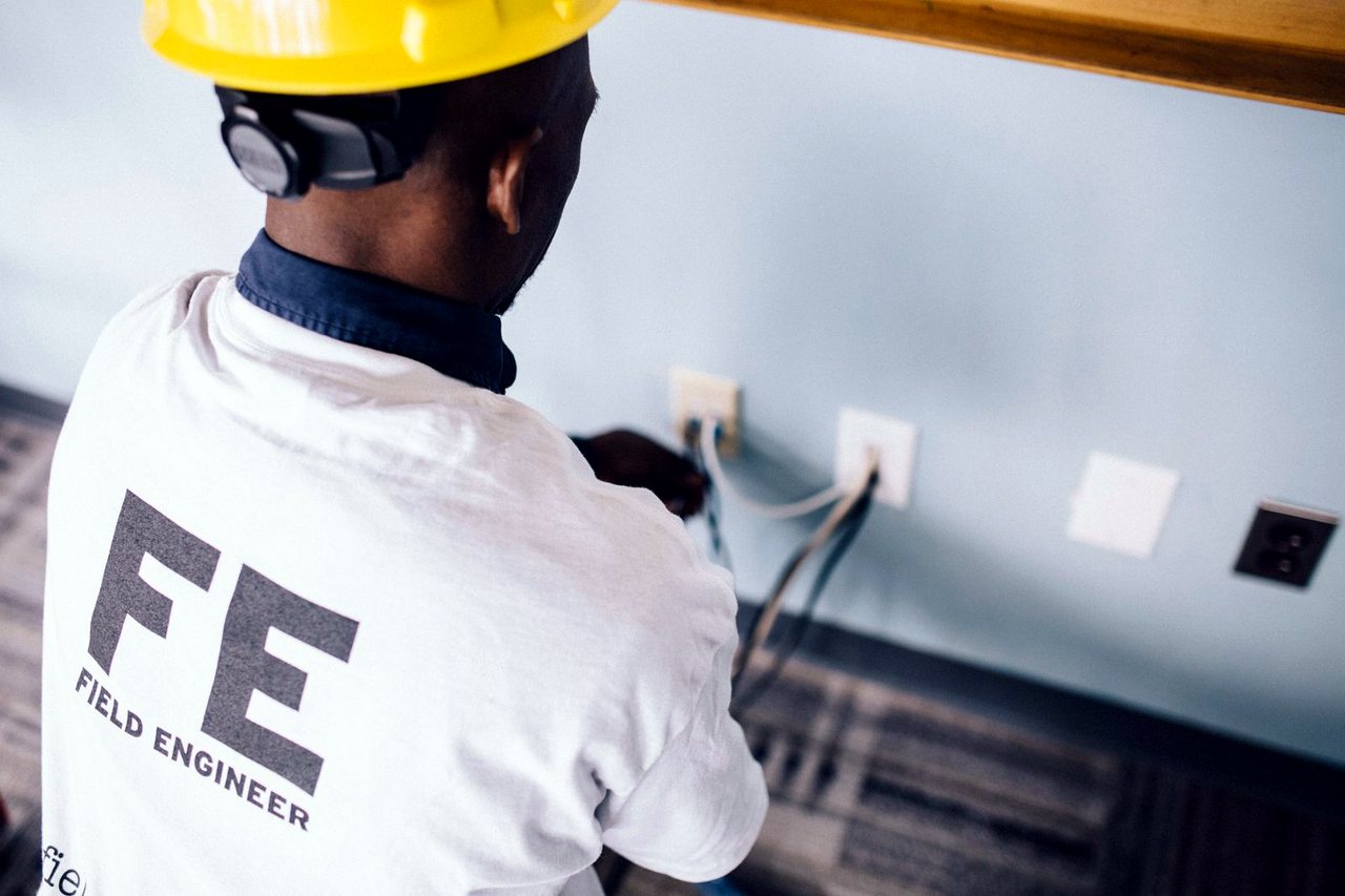 Elektriker prüft und verkabelt Steckdosen an der Wand.