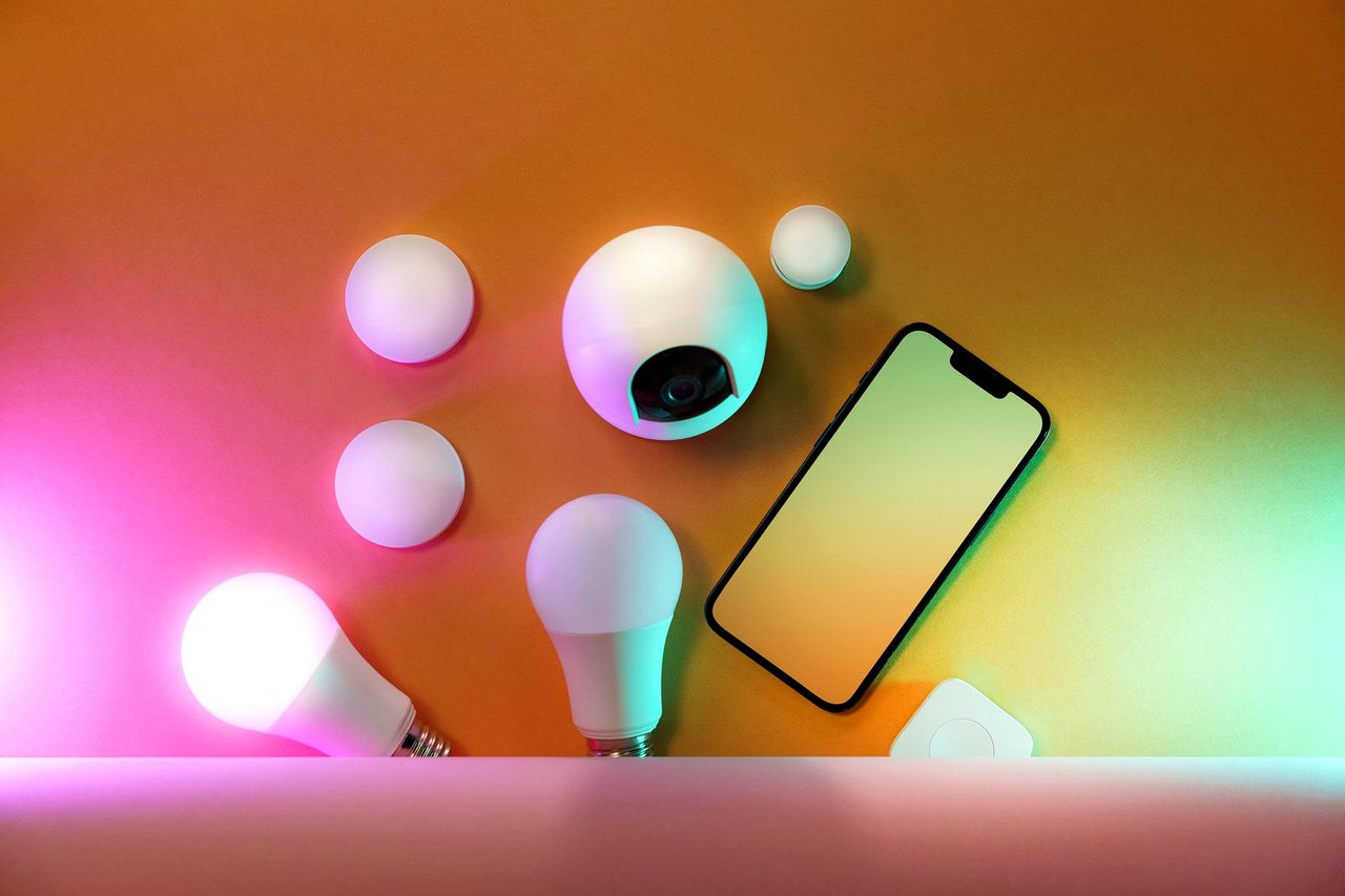 Smart-Home-Komponenten wie Leuchten und Kamera mit App-Steuerung.