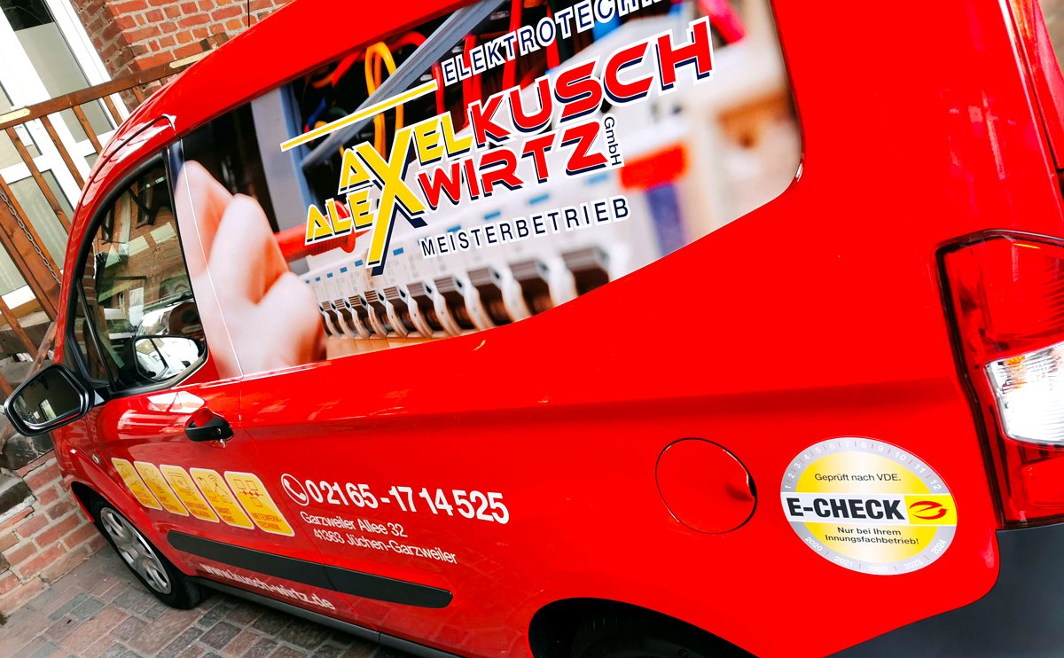Roter Firmenwagen von Kusch & Wirtz mit E-Check-Plakette in Jüchen-Garzweiler.